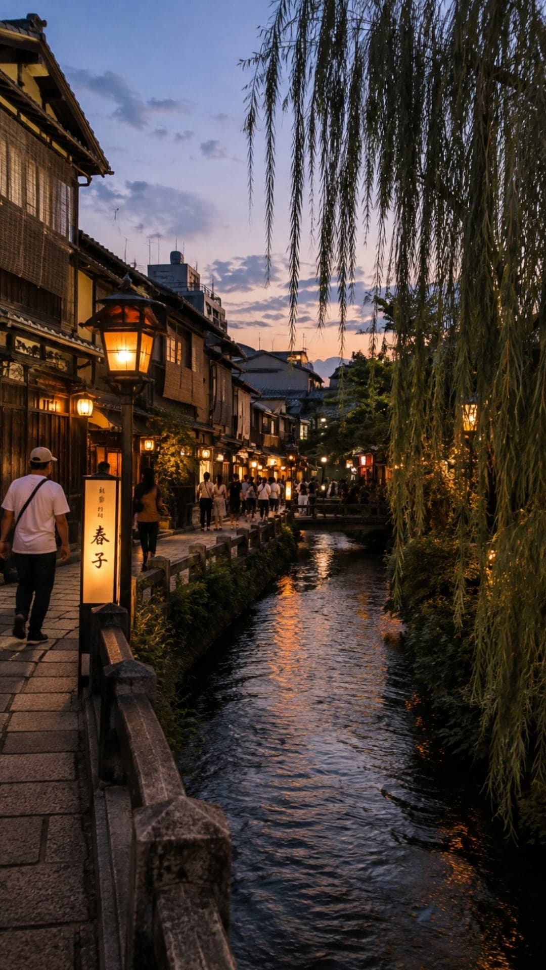 A quiet canal in Kyoto's Gion district at dusk, lanterns lit